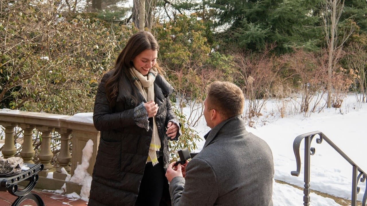 Anthony Schiano kneels with a ring with Caroline Ix in a garden