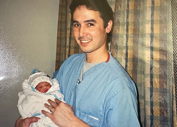 Dr. Dennehy holds Zeel Patel as a baby