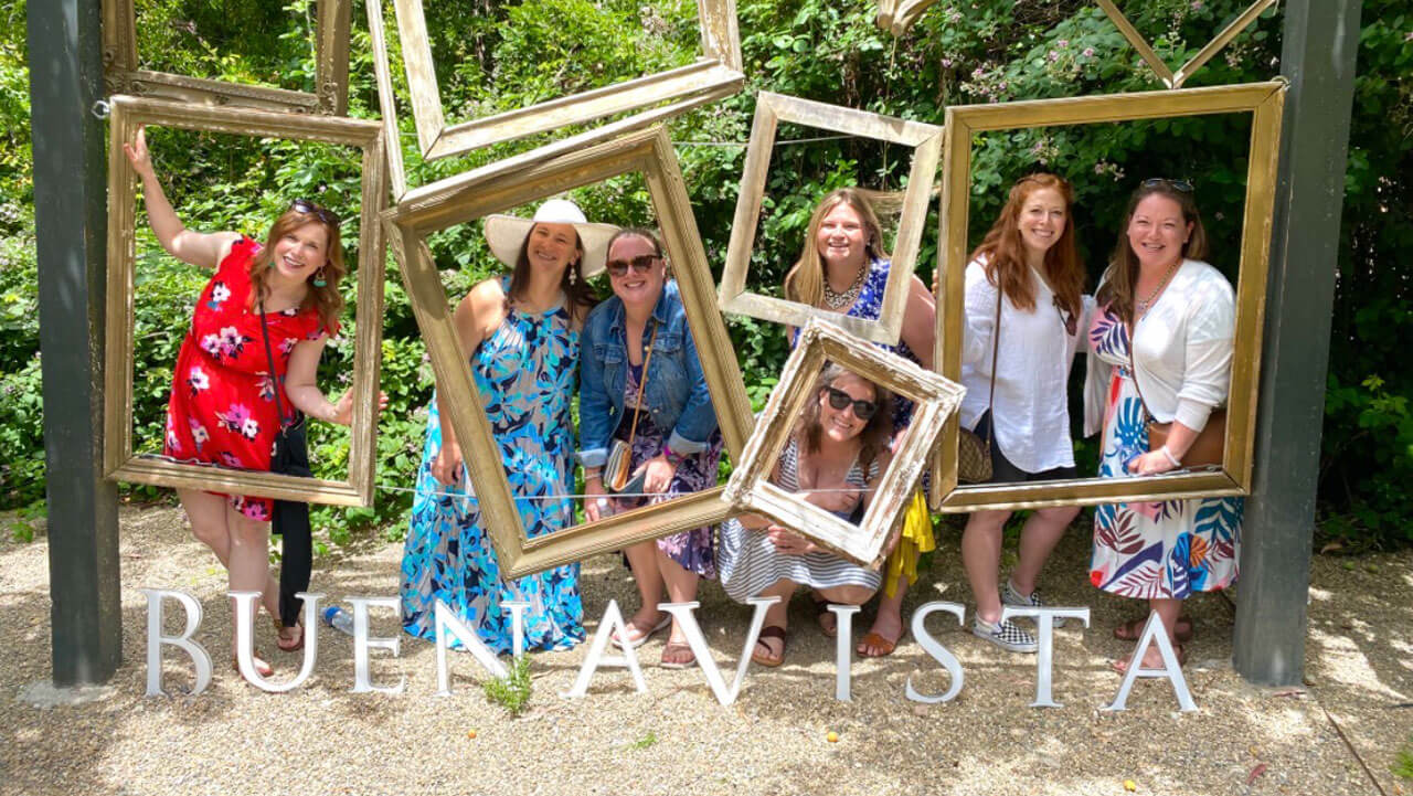 Quinnipiac alumna Amy Crain poses for a picture with her roommates inside a series of picture frames
