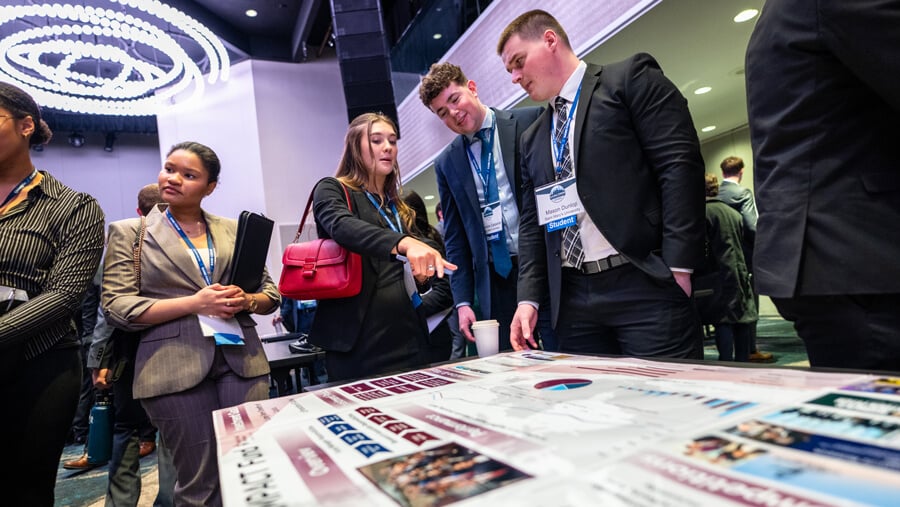 Student attendees observe competing schools' portfolio poster presentations.