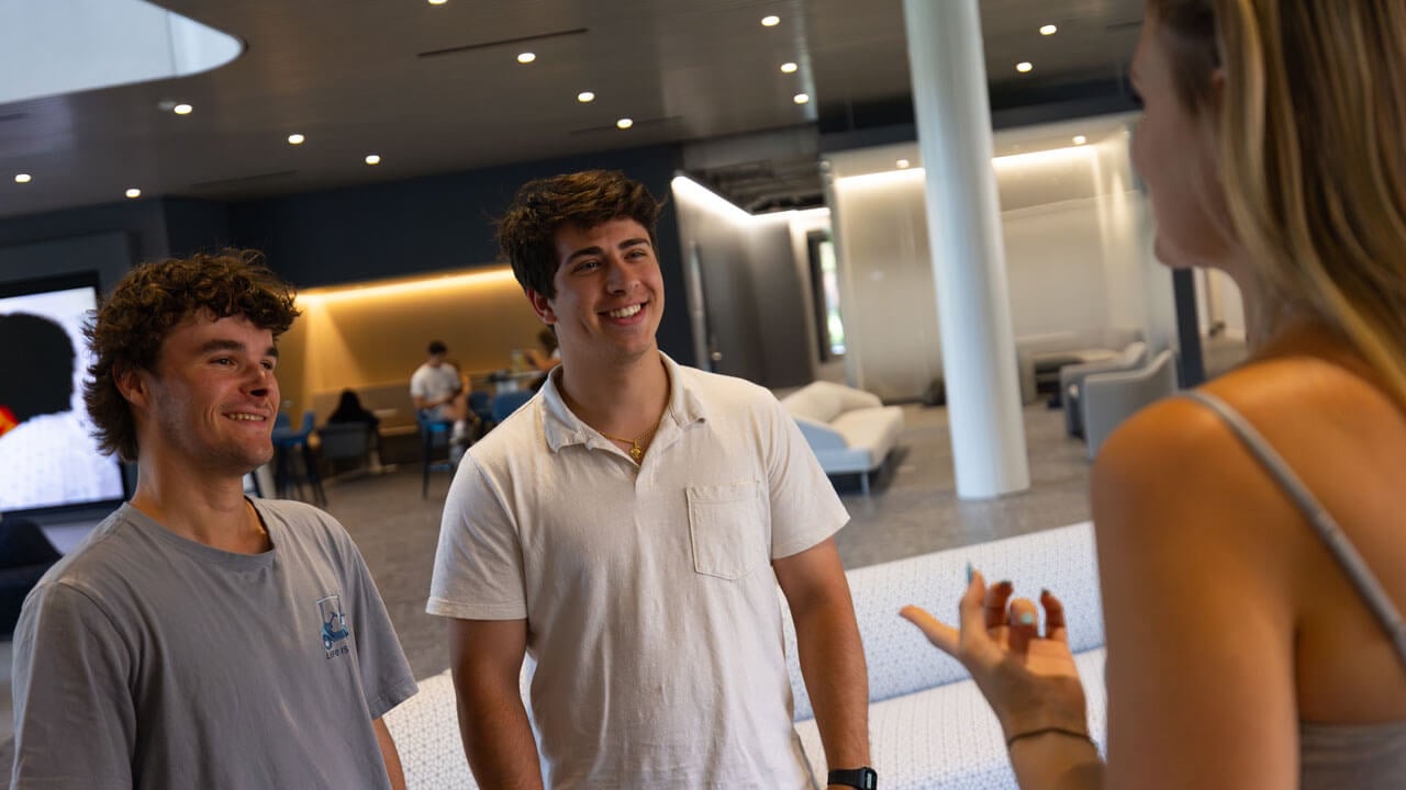 Three students talking in the SITE lobby