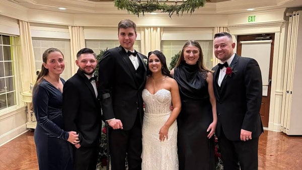 A group of Quinnipiac alumni pose for a photo at a wedding
