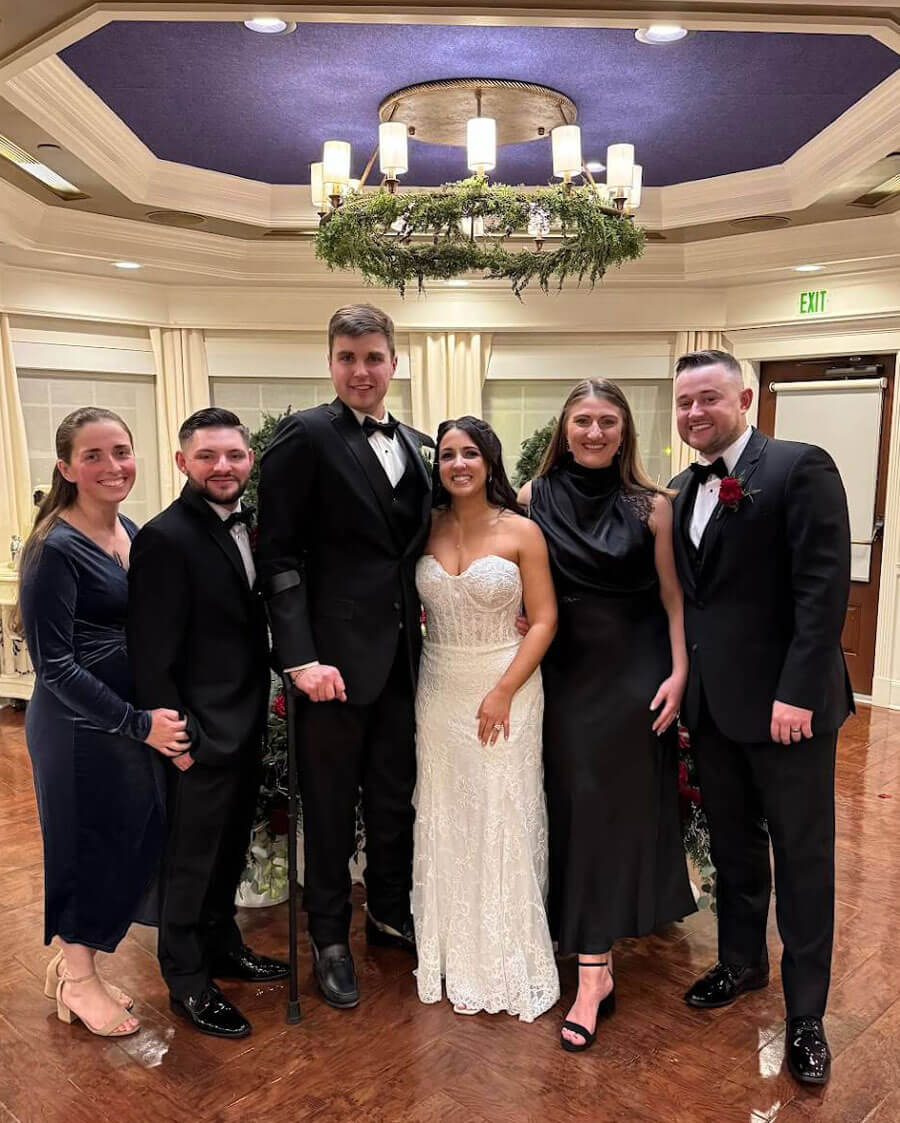 A group of Quinnipiac alumni pose for a photo at a wedding