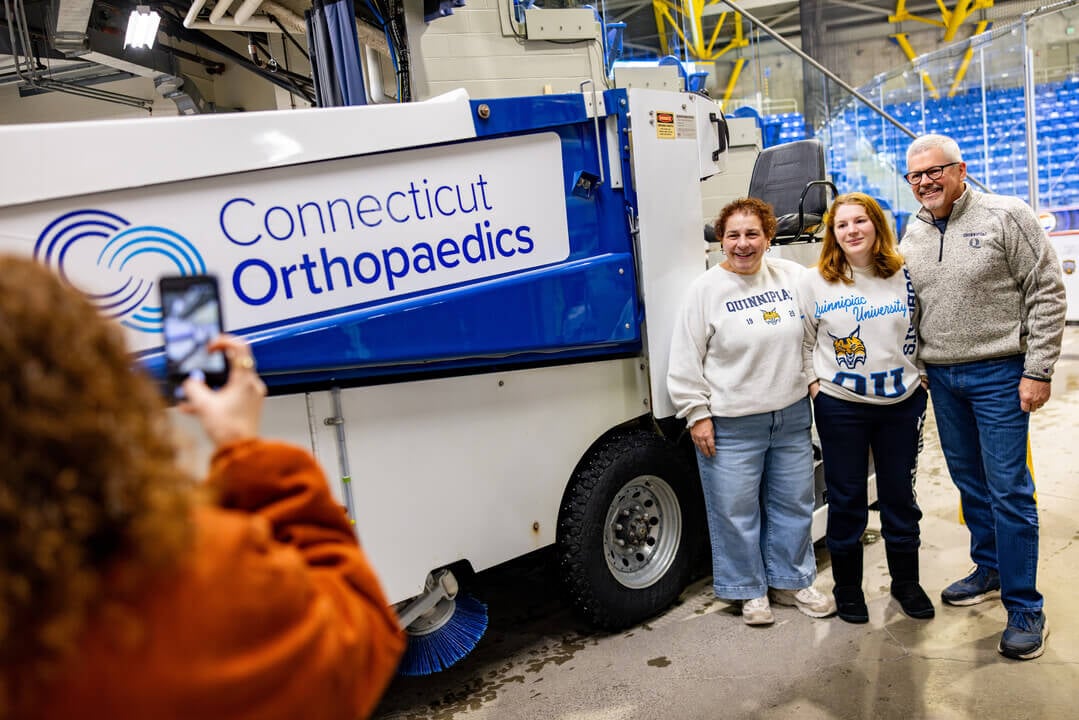 Family smiling for a photo infront of Zamboni
