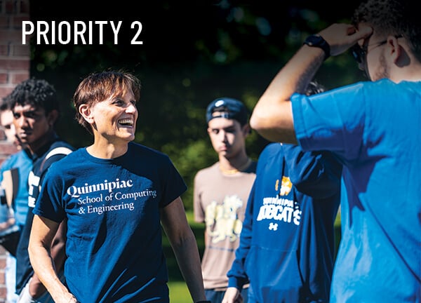 Priority 2: An engineering faculty member interacts with students during a bottle rocket launch outside