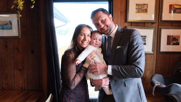 two people smiling holding a baby between each other