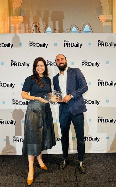 Ben Teicher poses with his award and another person from PR Daily