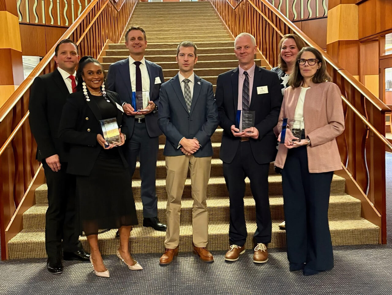 Winners of the 2025 law association alumni awards pose for a photo on the library stairway