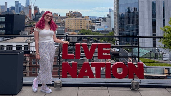 Jennifer Moglia poses on a rooftop next to a Live Nation sign