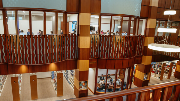 Students talking in team study rooms in the Quinnipiac Law library